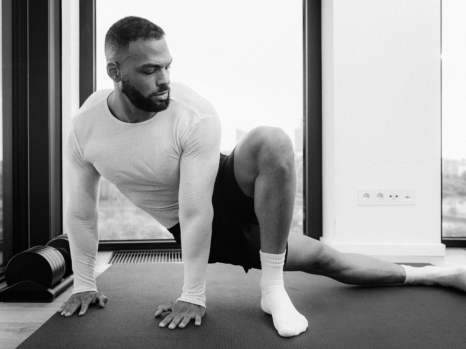 Anthony Green in a deep lunge stretch on a mat